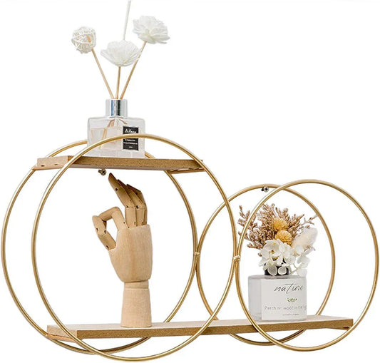 Gold circular metal shelf with wooden hand model and white flower diffuser and dried floral decor
