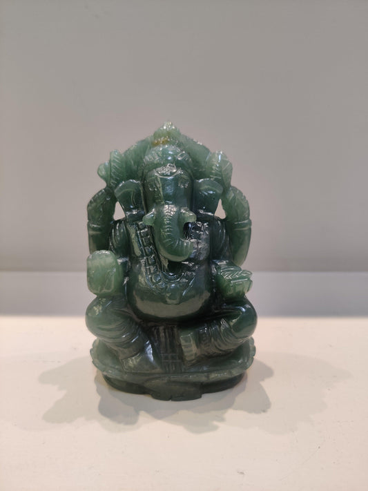 Green jade statue of Hindu deity Ganesha on a plain white surface